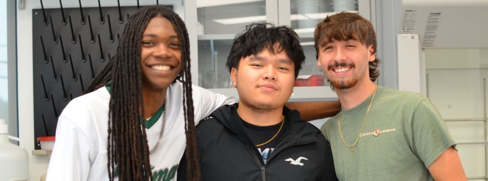 divers group of three male acc students standing together and smiling at the camera