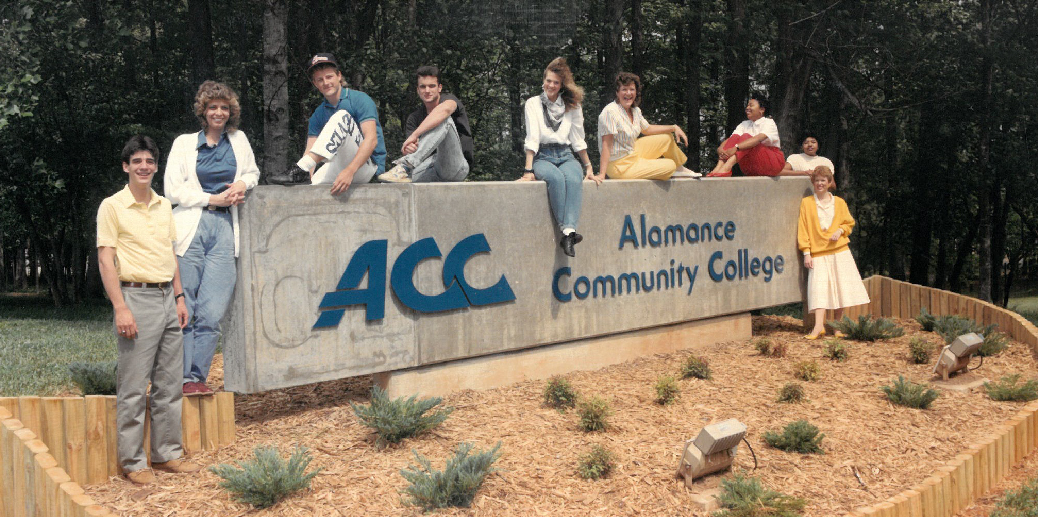 students sitting on acc monument sign