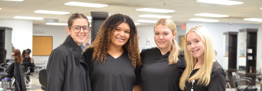 group of female cosmetology students smiling at camera