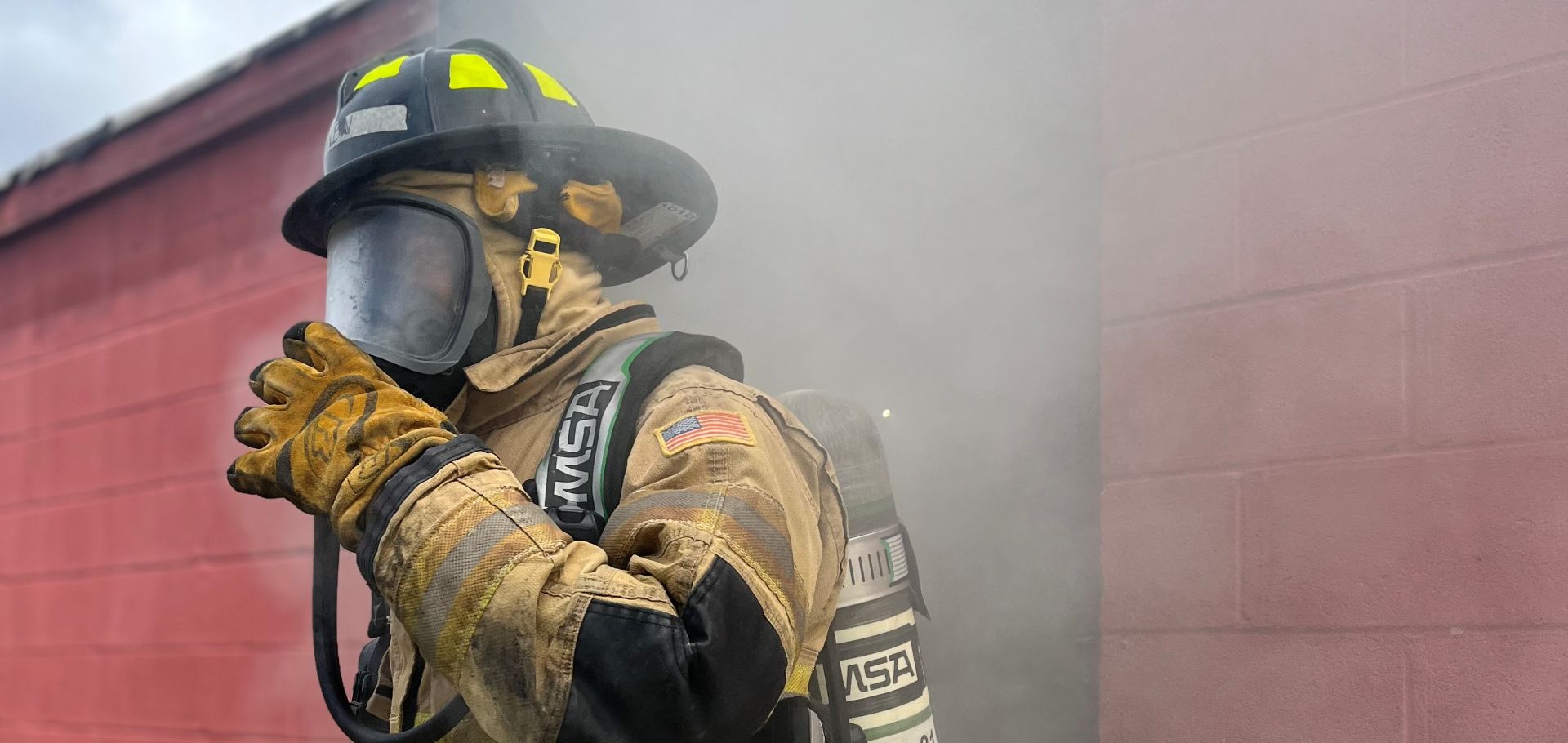 fire protection fire protectionstudent in their turnout gear in front of a live burn building
