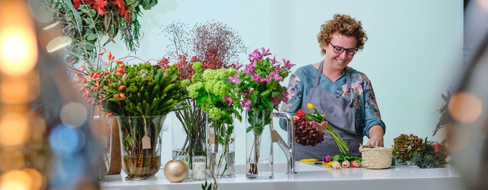 cheerful woman arranging flowers